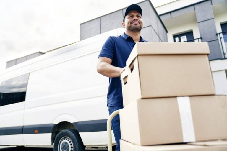 Delivery driver moving parcels on hand truck